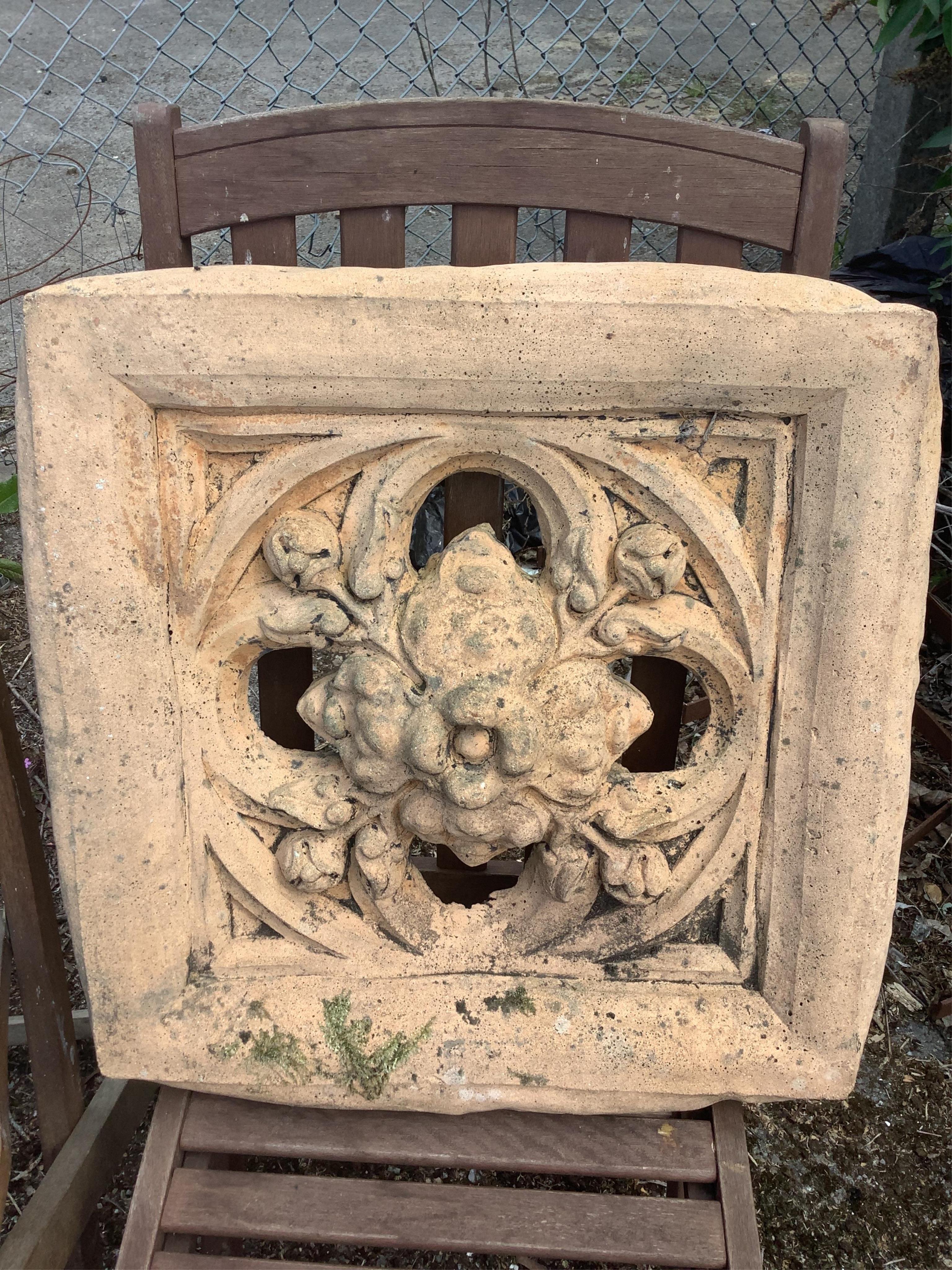 A Gothic style cast stone garden wall plaque and a terracotta tile, larger width 56cm, height 58cm
